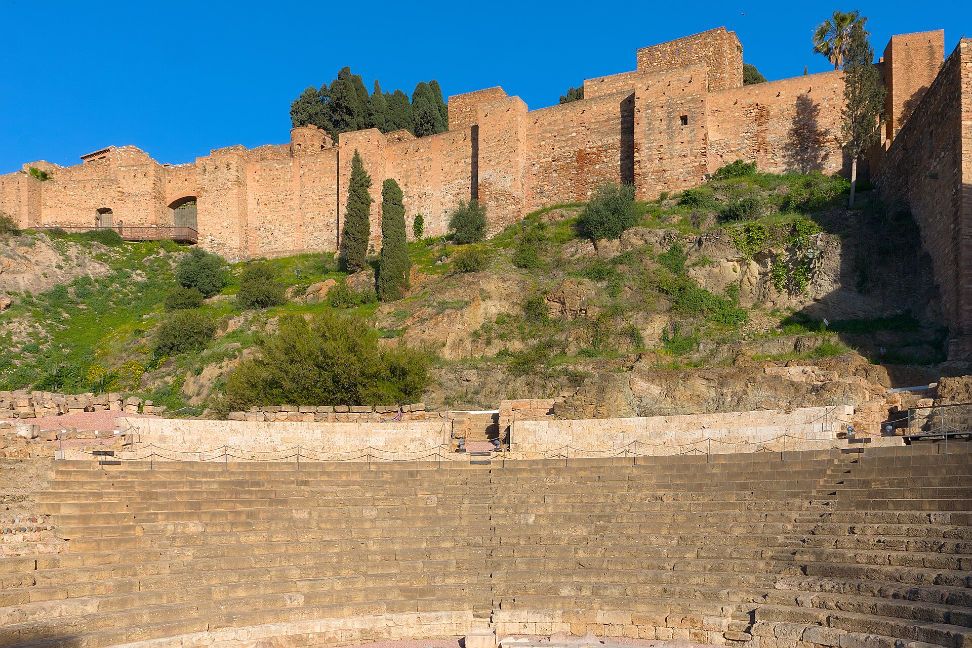 반원형 좌석의 말라가 로마 극장 뒤로 알카사바 성벽이 보이는 풍경