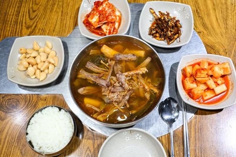 국물 한 그릇과 공깃밥, 마늘, 김치, 깍두기가 함께 놓인 부민옥 상차림