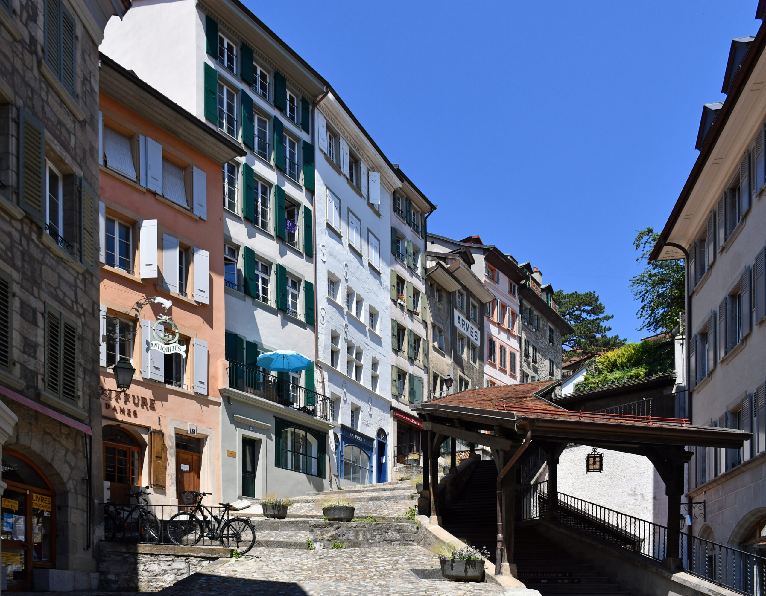 지붕이 덮인 목조 계단과 상점들이 이어지는 로잔 구시가지 계단길