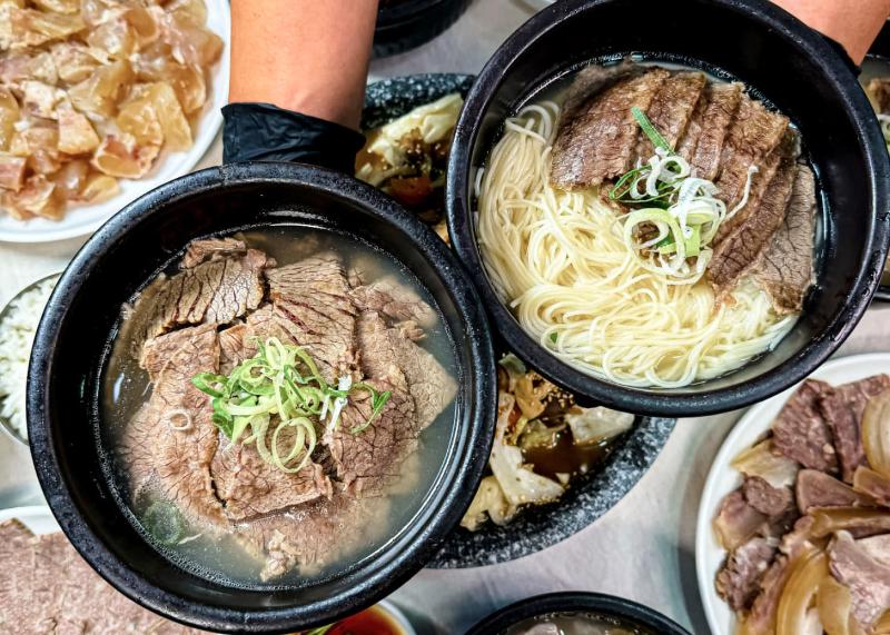 은호식당 상차림에서 검은 뚝배기 두 그릇과 수육 접시가 함께 놓인 식탁 모습