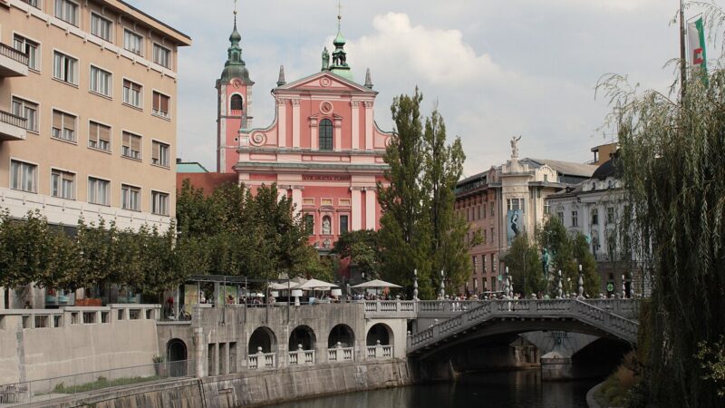 류블랴니차 강 위 아치형 다리와 분홍색 프란치스칸 교회가 보이는 류블랴나 도심 풍경
