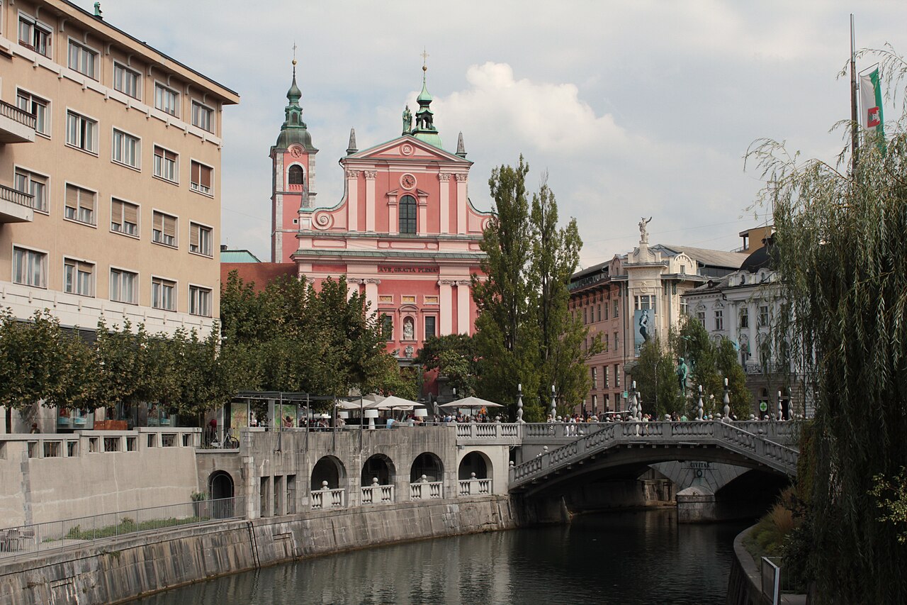 류블랴니차 강 위 아치형 다리와 분홍색 프란치스칸 교회가 보이는 류블랴나 도심 풍경