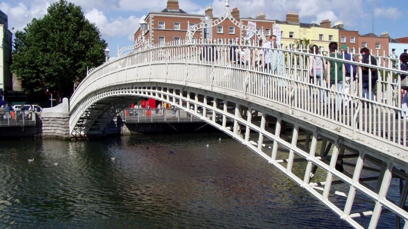 더블린 리피강 위로 하페니 브리지가 걸쳐 있고 강변 건물이 이어지는 전경