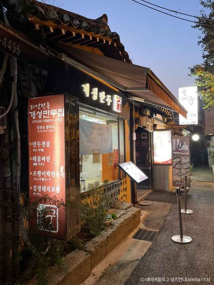 저녁 시간 불이 켜진 개성만두 궁 인사동 본점 외관과 만두전골 메뉴 안내판