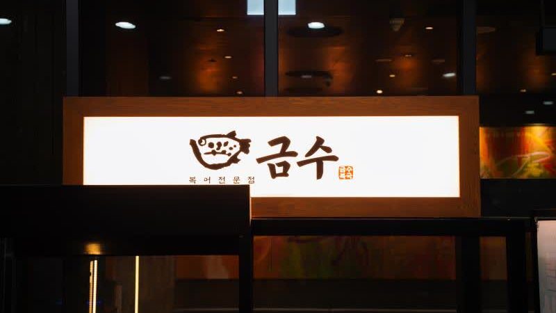 잠실 소피텔 지하 금수복국 잠실소피텔점의 물고기 로고와 금수복국 간판이 보이는 야간 표지