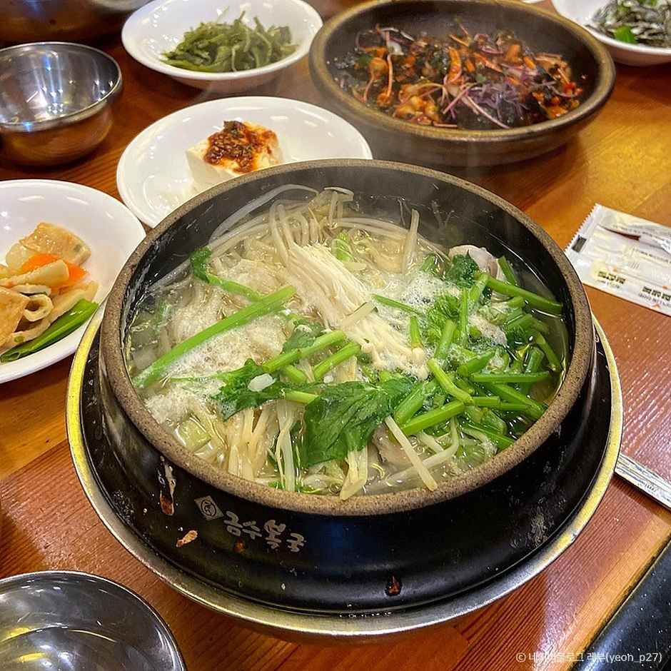 부산 금수복국 해운대본점의 복국 한 상과 두부 반찬, 나물, 밥이 함께 놓인 테이블