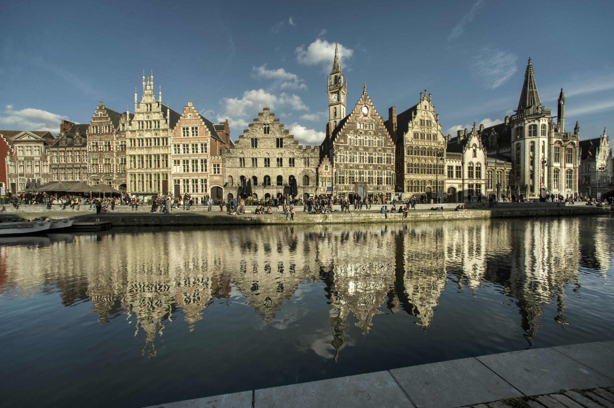 운하 수면에 반영된 길드하우스와 시계탑이 보이는 겐트 그라슬레이 저녁 풍경