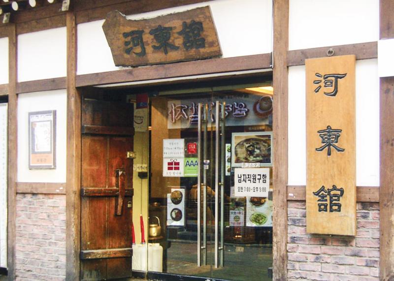 서울 명동 하동관 명동본점 유리문 입구와 목재 간판, 영업 안내가 보이는 정면