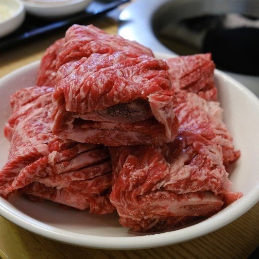 해운대암소갈비집에서 불판에 올리기 전 두툼한 생갈비 고기 결이 보이는 접시