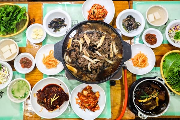 불갈비 전골과 김치, 쌈채소, 여러 반찬이 함께 놓인 진고개 한 상