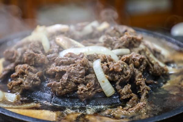 뜨거운 철판 위에서 양파와 함께 익는 진고개 동대문점 불갈비 가까운 모습