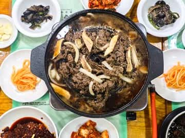 불갈비 전골 냄비와 곁들임 반찬이 중심에 보이는 진고개 한식 상차림 디테일