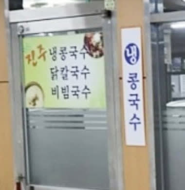 서울 여의도 진주집 입구 한쪽에 메뉴 안내판과 출입문이 보이는 장면