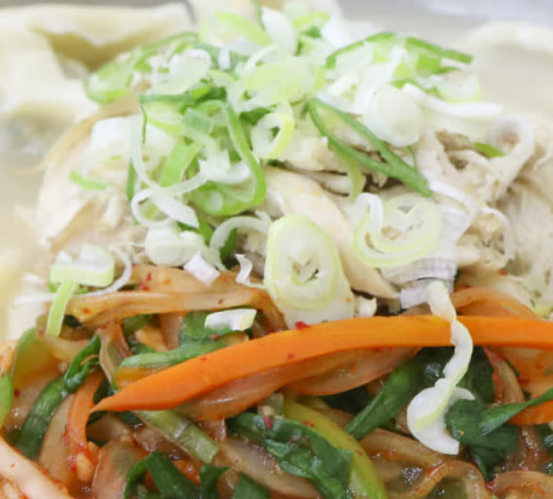 서울 여의도 진주집 면 요리 위에 파 고명과 고기, 채소가 올라간 클로즈업