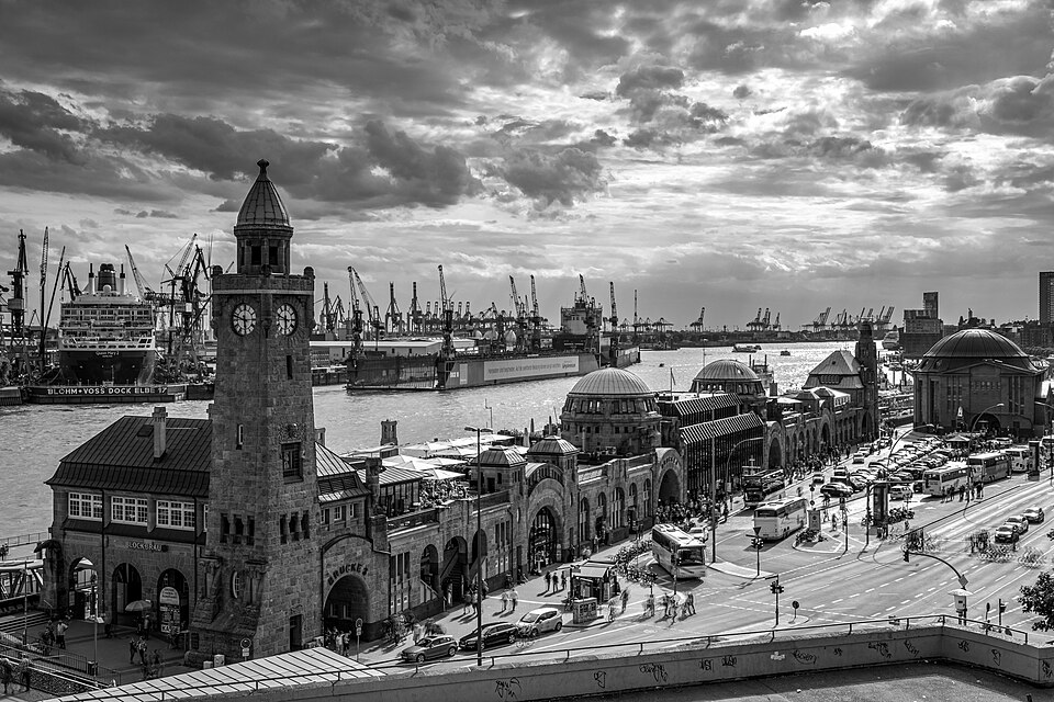 시계탑과 부두 건물이 이어지고 뒤로 항만 크레인이 보이는 함부르크 란둥스브뤼켄