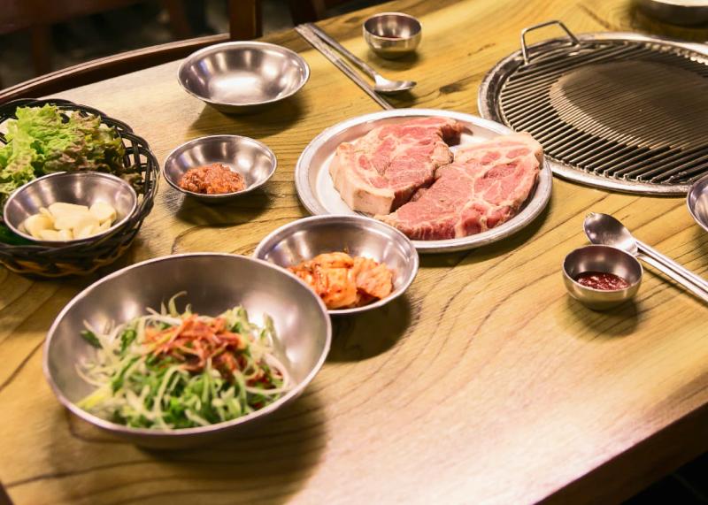 마포진짜원조최대포 생고기와 상추, 마늘, 파절이가 놓인 불판 상차림