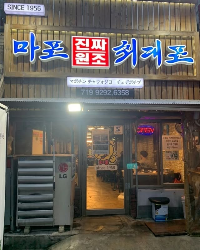 밤에 본 마포진짜원조최대포 입구와 나무 외벽, OPEN 네온사인