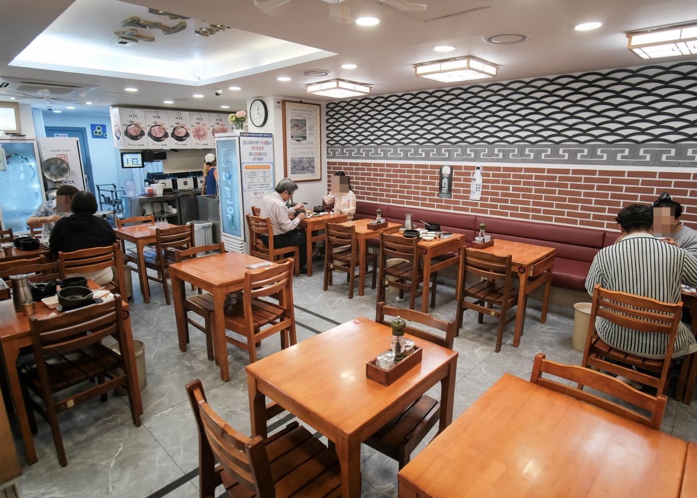 서울 마포 마포옥 내부 나무 테이블과 벤치 좌석, 식사 중인 손님들이 보이는 실내