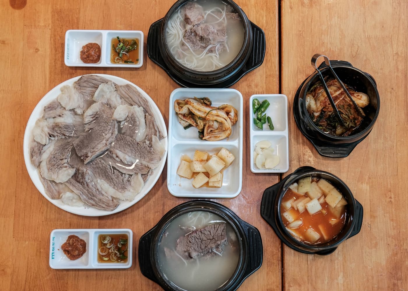 서울 마포 마포옥 소고기 국물 식사 한 상과 고기 접시, 김치와 깍두기 반찬이 놓인 테이블