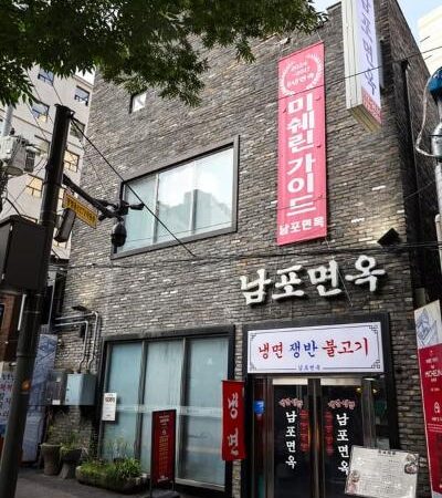 서울 중구 다동 남포면옥 외관과 회색 벽돌 건물, 세로 간판이 보이는 거리 풍경