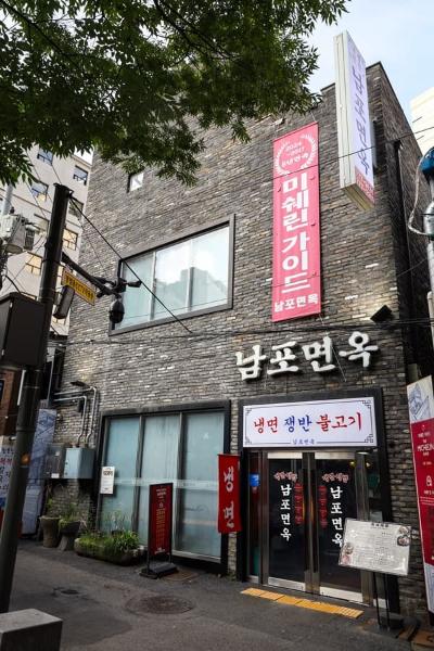 서울 중구 다동 남포면옥 외관과 회색 벽돌 건물, 세로 간판이 보이는 거리 풍경