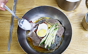 서울 오장동흥남집 본점 비빔냉면에 달걀과 오이 고명, 양념이 올라간 디테일