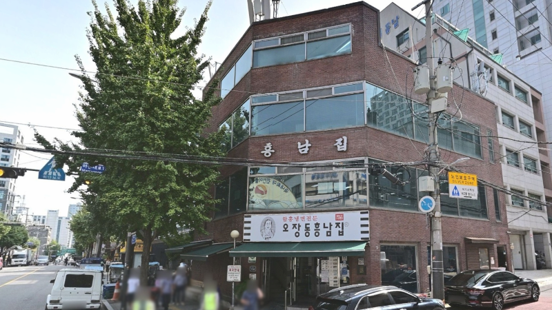 서울 중구 오장동흥남집 본점 건물 외관과 초록 차양, 거리 풍경이 함께 보이는 모습