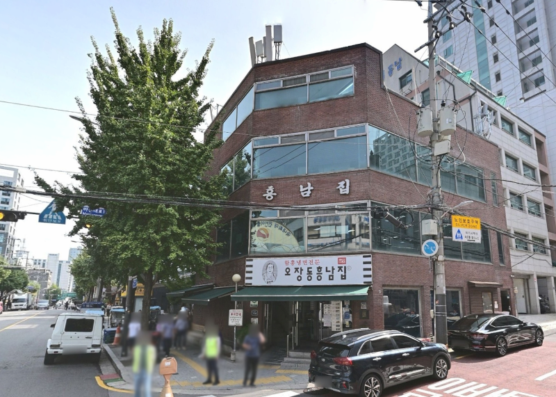 서울 중구 오장동흥남집 본점 건물 외관과 초록 차양, 거리 풍경이 함께 보이는 모습