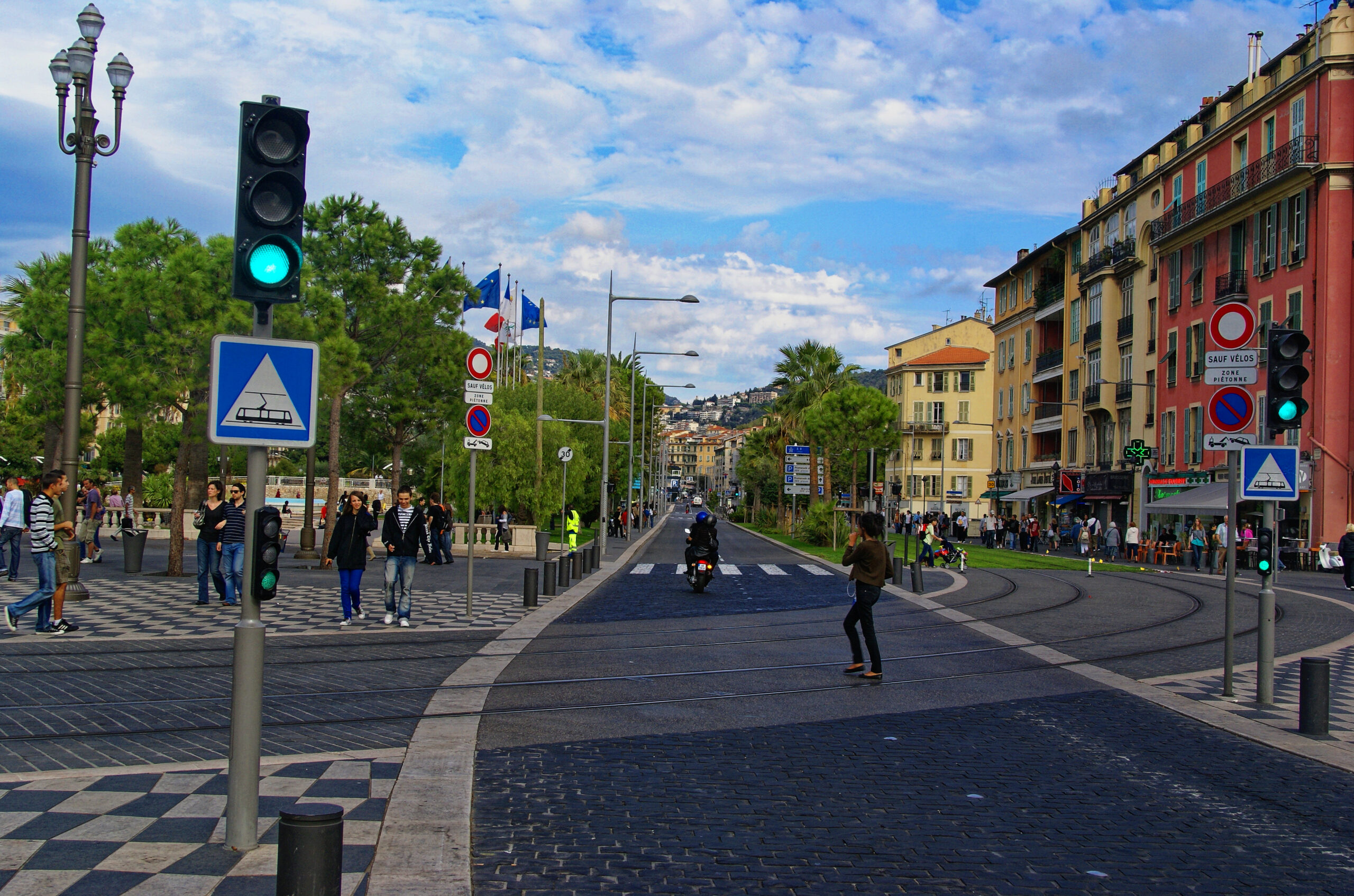 검은 바닥 패턴과 트램 선로, 프랑스 국기와 파스텔 건물이 보이는 니스 플라스 마세나 권역