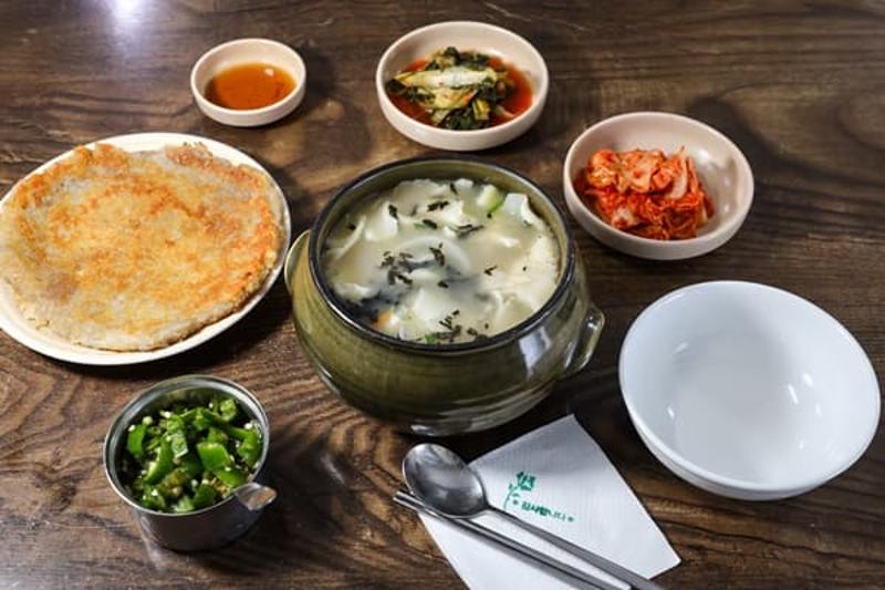 삼청동 수제비 한 상과 감자전, 김치가 함께 놓인 식탁