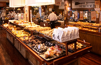 대전 성심당 본점 내부 빵 진열대와 따뜻한 조명, 손님 동선이 보이는 베이커리 실내