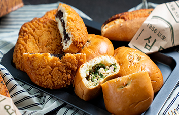 성심당 대표 빵들이 한 트레이에 담겨 있는 모습으로 튀김소보로와 여러 빵이 함께 보이는 장면