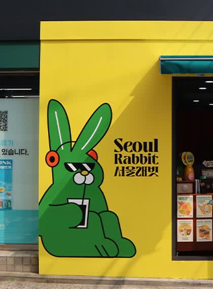 서울 래빗 외벽의 초록 토끼 벽화와 서울 래빗 로고를 가까이 담은 장면