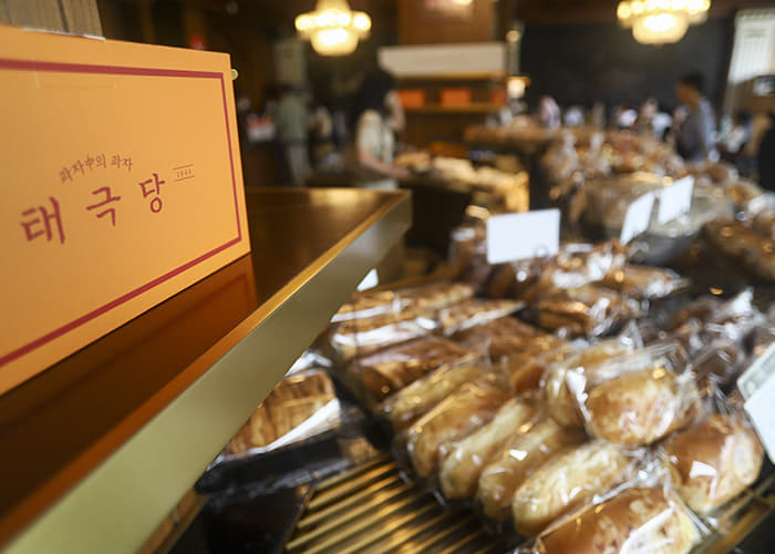 태극당 본점 내부에서 태극당 간판과 포장된 빵 진열대가 보이는 장면