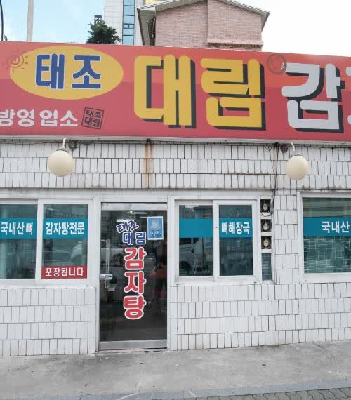태조대림감자국 입구 유리문과 감자탕 전문 문구, 붉은 간판이 가까이 보이는 장면