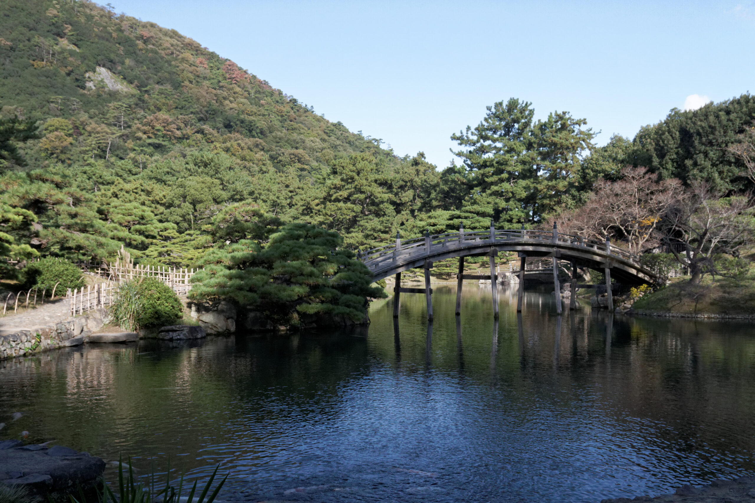 일본 가가와현 다카마쓰 리쓰린공원 연못과 아치형 목조 다리 풍경