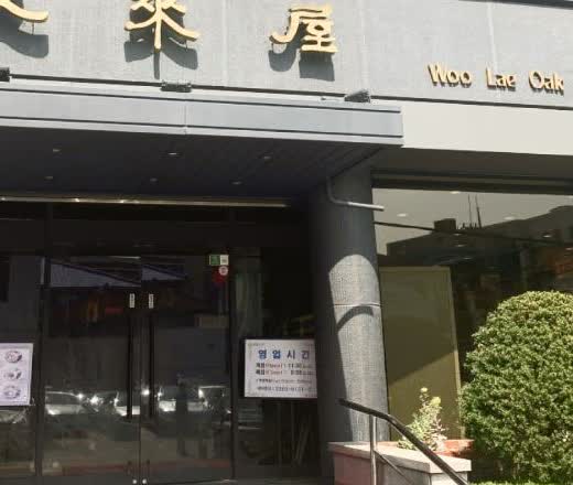 서울 을지로 우래옥 입구와 Woo Lae Oak 영문 간판, 유리문이 보이는 장면
