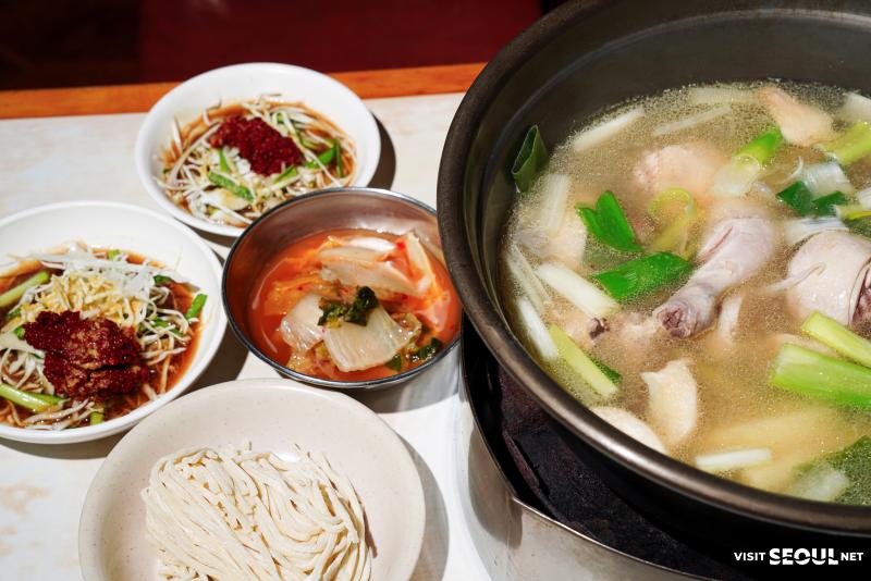 원할매 소문난 원조 닭한마리 닭한마리 한 냄비와 국수 사리, 김치와 양념장이 놓인 상차림