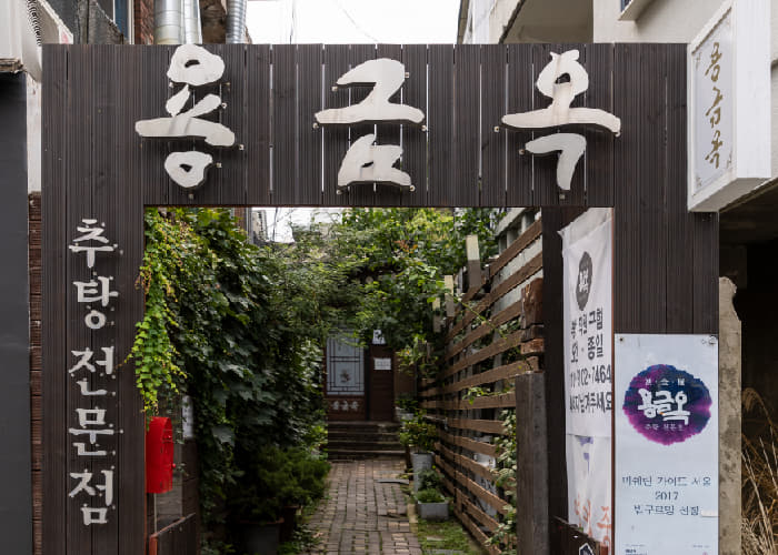 담쟁이 넝쿨 사이로 보이는 용금옥 입구와 큰 한글 간판