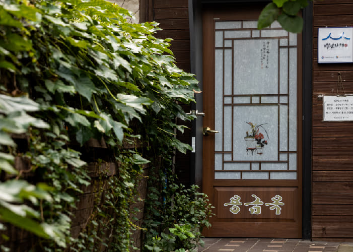 전통 문양 유리문과 나무 외벽이 보이는 용금옥 입구