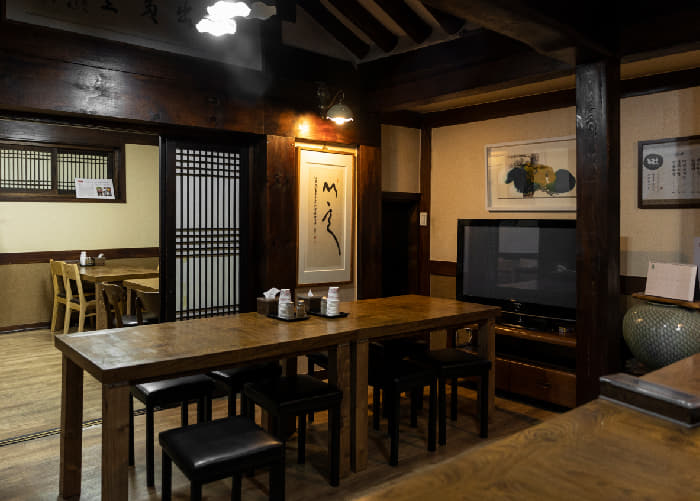 짙은 목재 인테리어와 좌석이 놓인 용금옥 실내