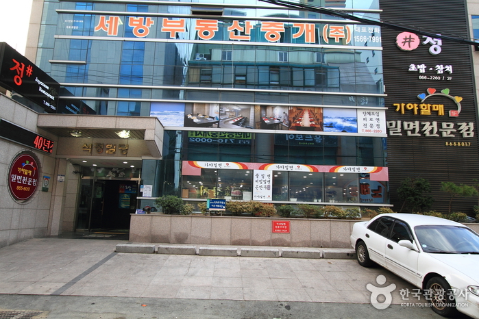 부산 연산동 가야할매밀면 건물 외관과 세로 간판, 전면 유리창이 보이는 거리 풍경