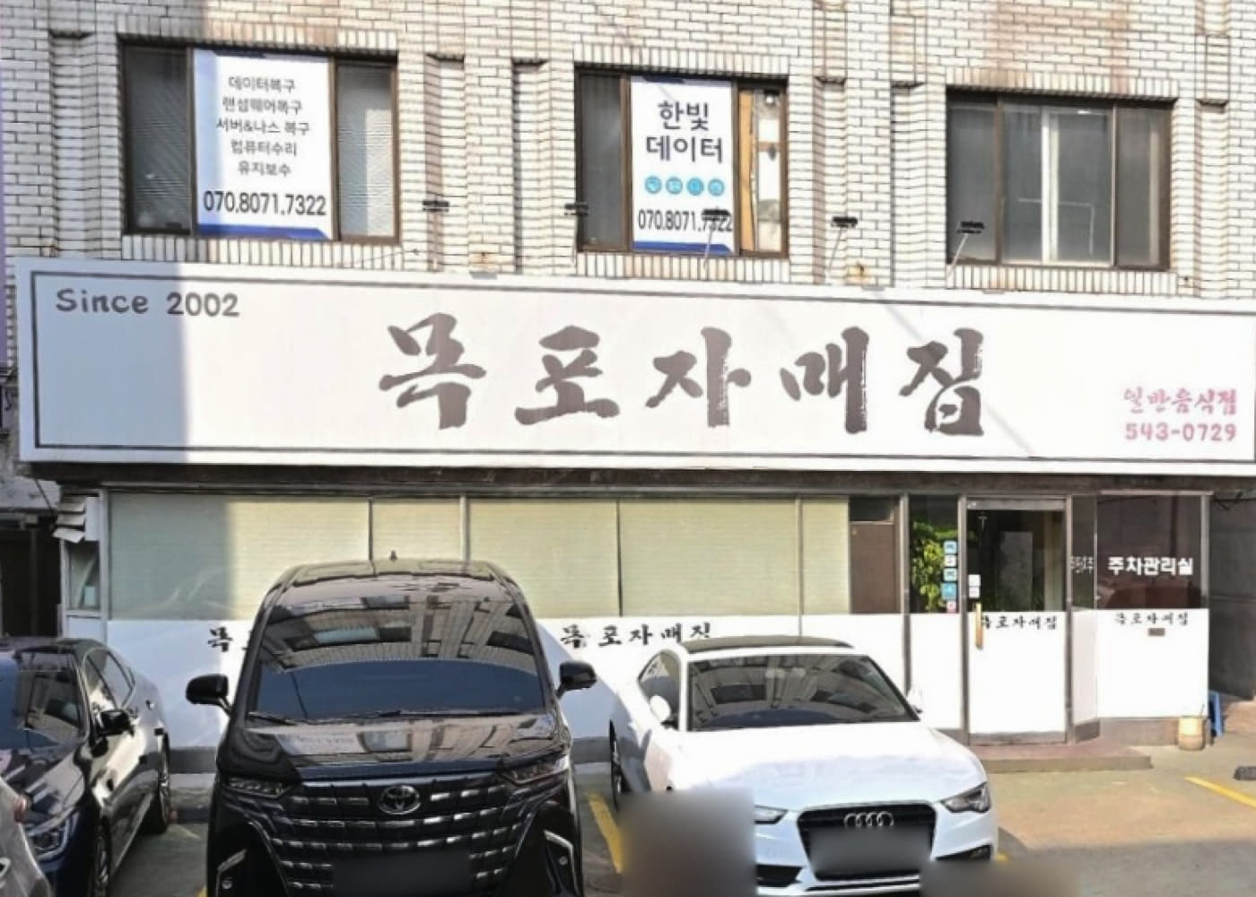 논현 골목의 목포자매집 외관과 흰 간판, 주차된 차들이 함께 보이는 거리 풍경