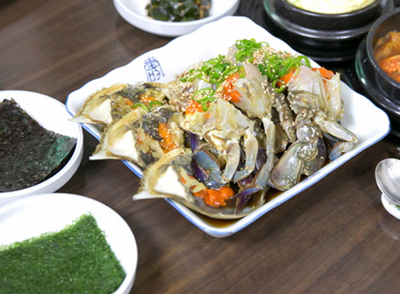 진미식당 간장게장 접시와 김, 반찬이 함께 놓인 테이블