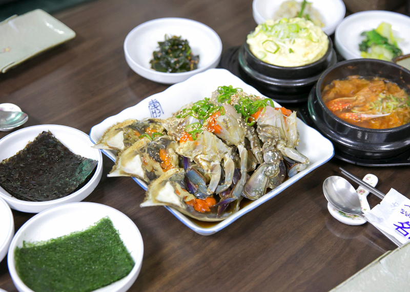 간장게장과 계란찜, 붉은 국물 냄비가 함께 놓인 진미식당 한 상