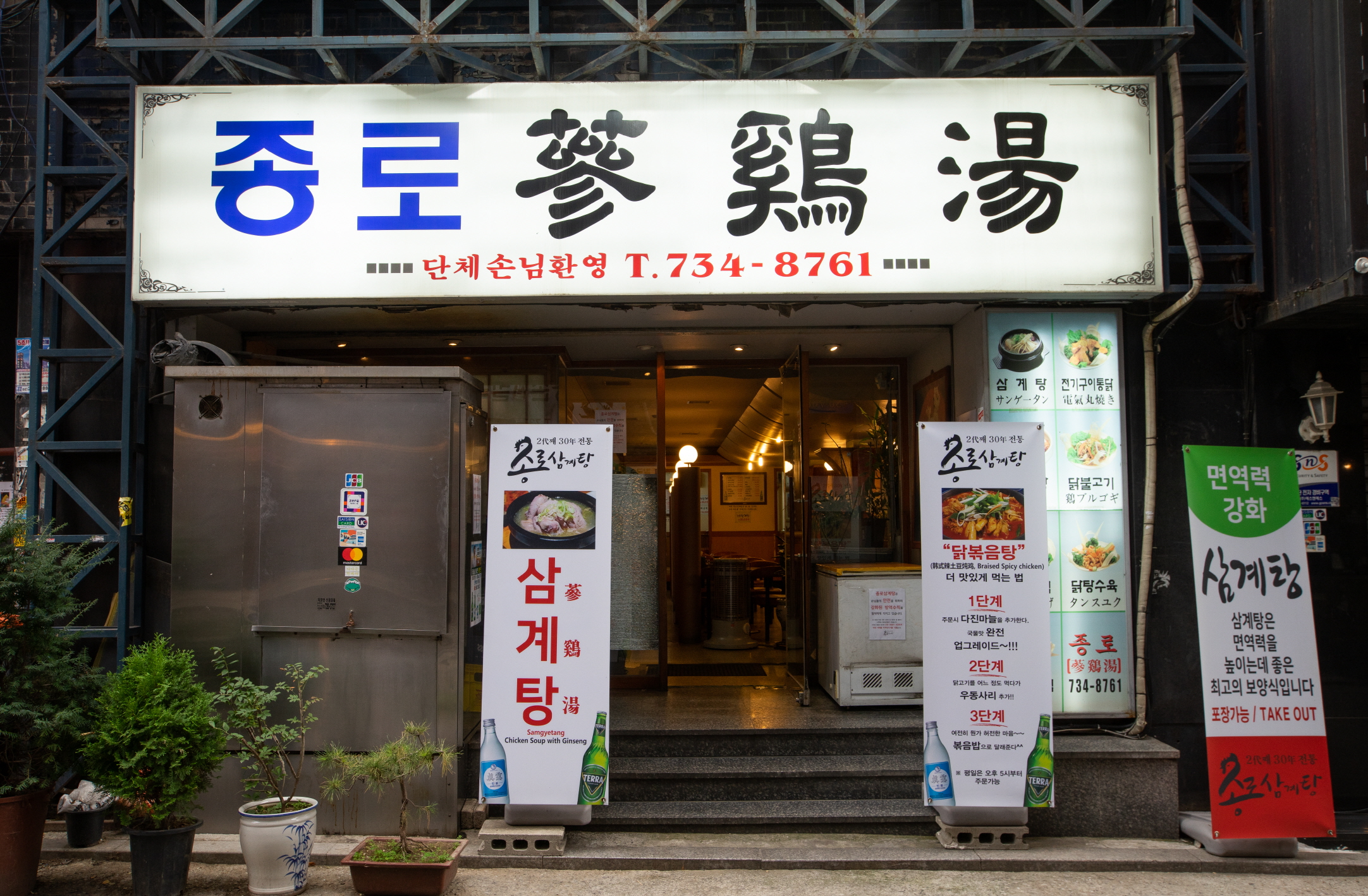 서울 종로 종로삼계탕 입구의 밝은 간판과 메뉴 보드, 계단이 보이는 외관