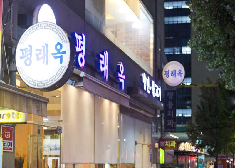 을지로 평래옥 외관과 둥근 간판이 보이는 밤거리 풍경