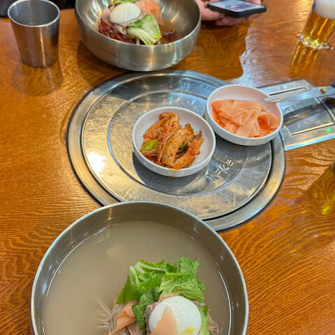 평래옥 냉면 두 그릇과 반찬이 놓인 실제 식탁 장면