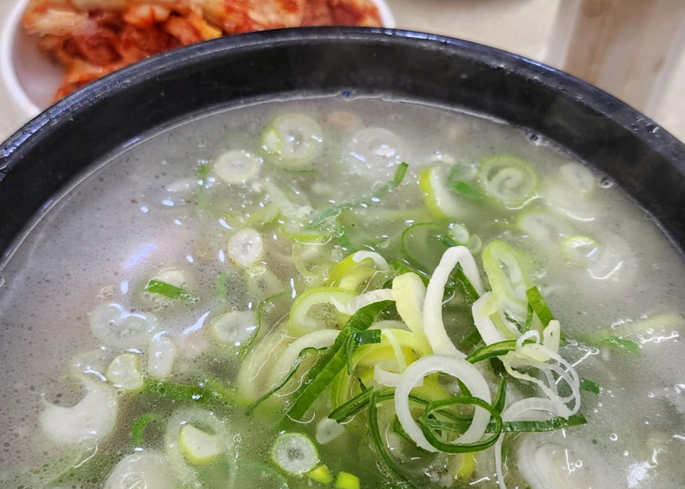 파를 넉넉히 올린 영동설렁탕 설렁탕 한 그릇과 김치 접시