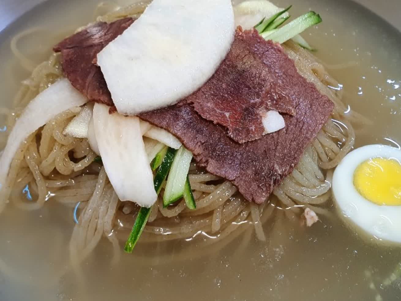 차가운 육수와 면발, 편육이 가까이 보이는 을밀대 본점 평양냉면 클로즈업